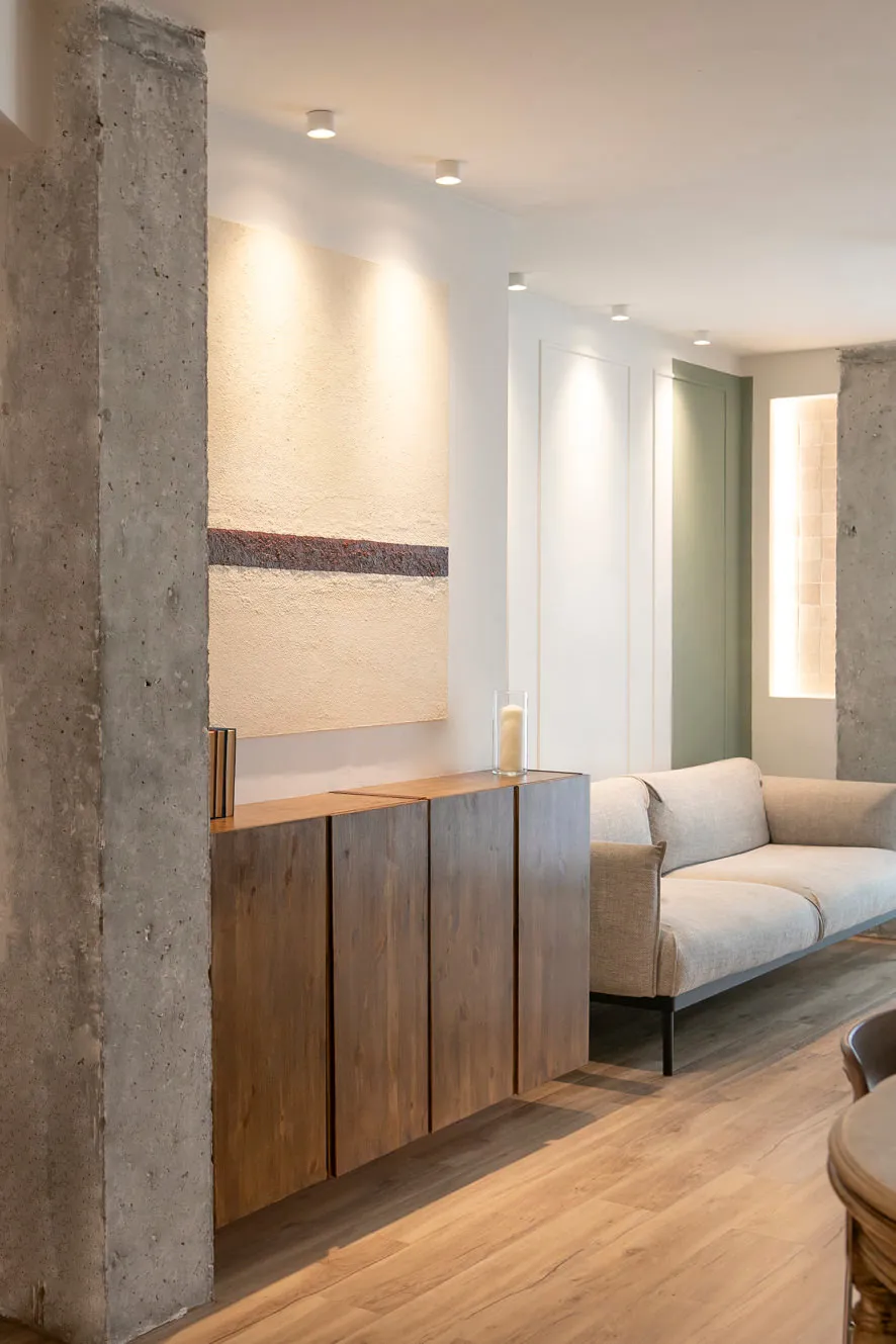 Salón reformado con distribución diáfana, luz natural y materiales continuos que unifican el espacio